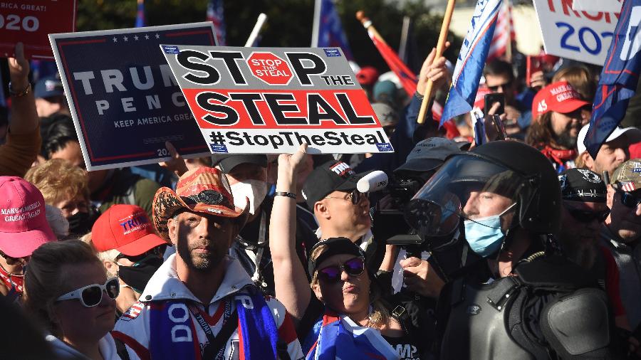 Os apoiadores de Trump levavam placas dizendo "pare o roubo" - Olivier DOULIERY / AFP