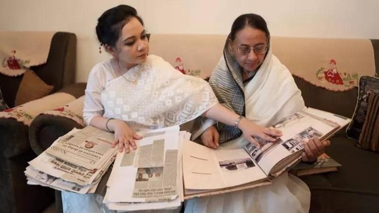 Shagufta Ahmed and her mother look at newspaper clippings recording their legal battle - Reproduction/BBC - Reproduction/BBC