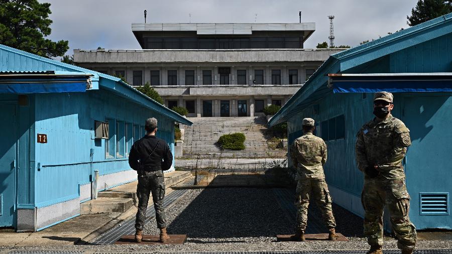 Soldados do UNC (Comando das Nações Unidas) e um soldado sul-coreano (à esquerda) montam guarda na linha de demarcação militar que separa as Coreias na Segurança Conjunta Área (JSA) em 4 de outubro de 2022