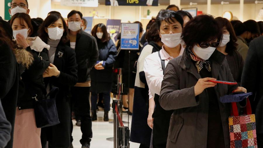 Pessoas de máscara fazem fila para comprar máscara em loja de Seul - Por Hyonhee Shin e Daewoung Kim