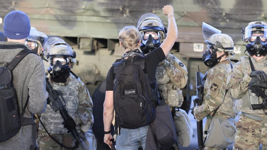 Manifestante ergue o braço em frente a agentes da Guarda Nacional em Minneapolis - Tannen Maury - 29.mai.2020/Efe