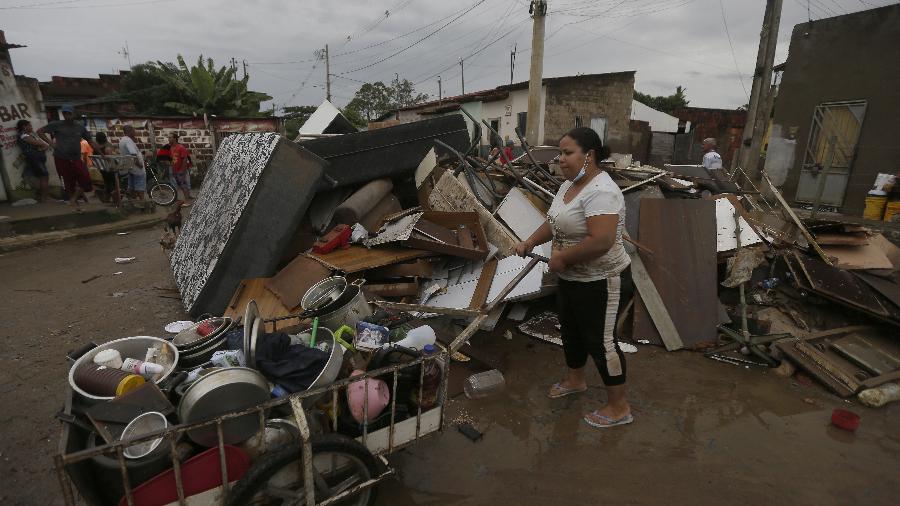 27.dez.2021 - Mulher empurra um carrinho com utensílios domésticos durante inundação provocada por fortes chuvas em Itapetinga, na Bahia - Xinhua/Lucio Tavora