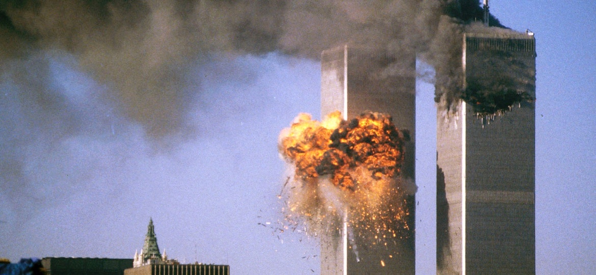 A torre sul do World Trade Center é atingida por avião enquanto a torre norte exala fumaça negra durante ataque terrorista em 11 de Setembro - REUTERS/Sean Adair