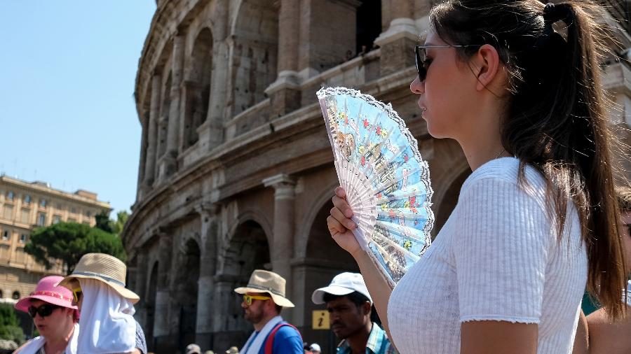 Turista se abana em frente ao Coliseu, em Roma, na Itália - Andreas SOLARO / AFP PHOTO