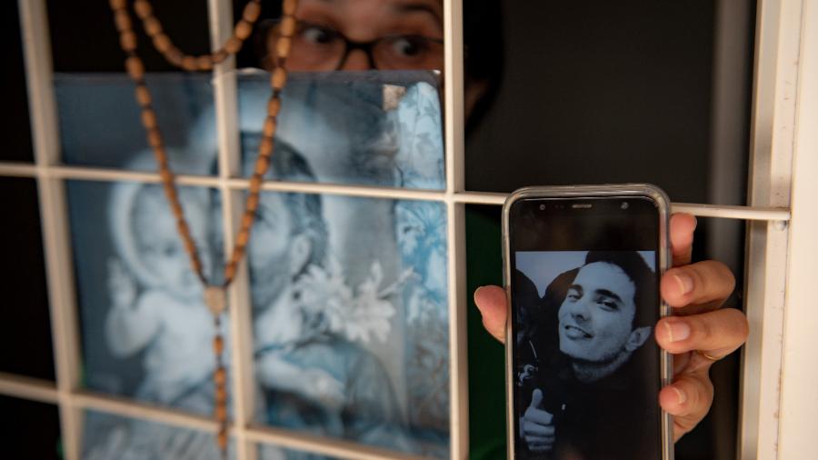 Parente segura celular com foto do desaparecido Paulo Gustavo de Lima Lopes, em Sinop (MT) - José Medeiros/UOL