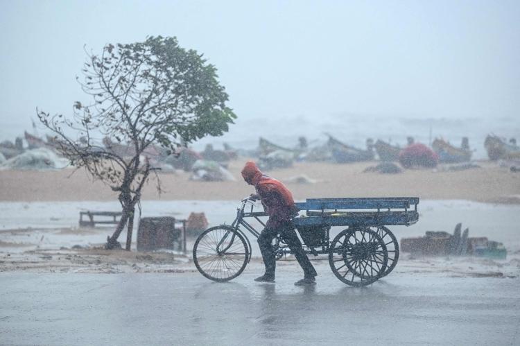 Homem enfrenta chuva em praia de Chennai, na Índia, atingida pelo ciclone Fengal