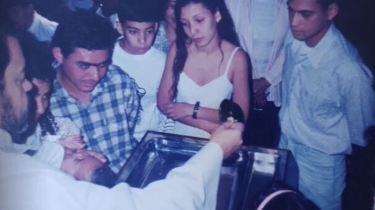 Leda Juliana observa o batizado da filha pelo padre Bernardino. Quatro anos depois o abuso aconteceria, ela denunciou Leda Juliana observa o batizado da filha pelo padre Bernardino. Quatro anos depois o abuso aconteceria, ela denunciou
