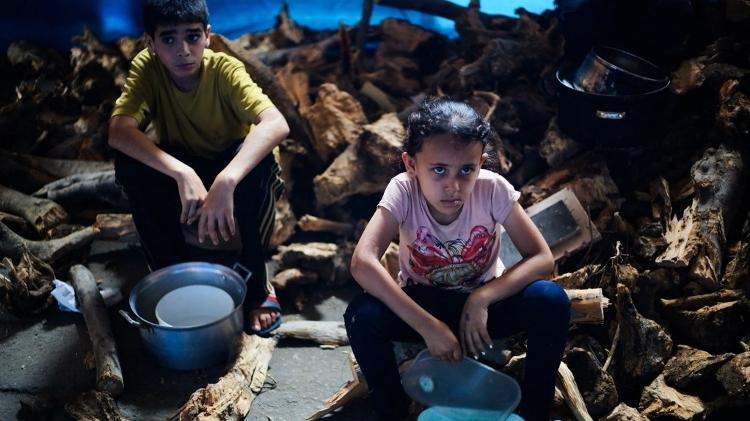 Crianças palestinas aguardam por comida em um ponto de distribuição em Nuseirat, centro da Faixa de Gaza Crianças palestinas aguardam por comida em um ponto de distribuição em Nuseirat, centro da Faixa de Gaza