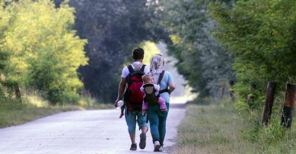 7.jul.2015 - Família imigrante caminha em direção à fronteira da Hungria em uma estrada na Sérvia. O parlamento da Hungria aprovou na segunda-feira (6) por maioria esmagadora a construção de um muro na fronteira com a Sérvia para impedir a entrada de imigrantes