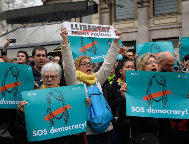 Manifestantes em Barcelona pedem "SOS Democracia" em seus cartazes - Lluis Gene/AFP