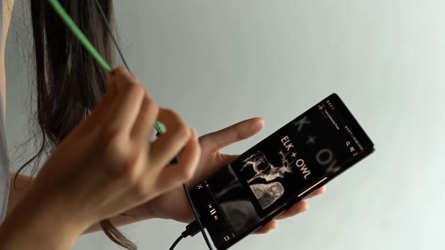 Jovem controla comandos do celular apertando um cordão - Reprodução/ Youtube/ Alex Olwal