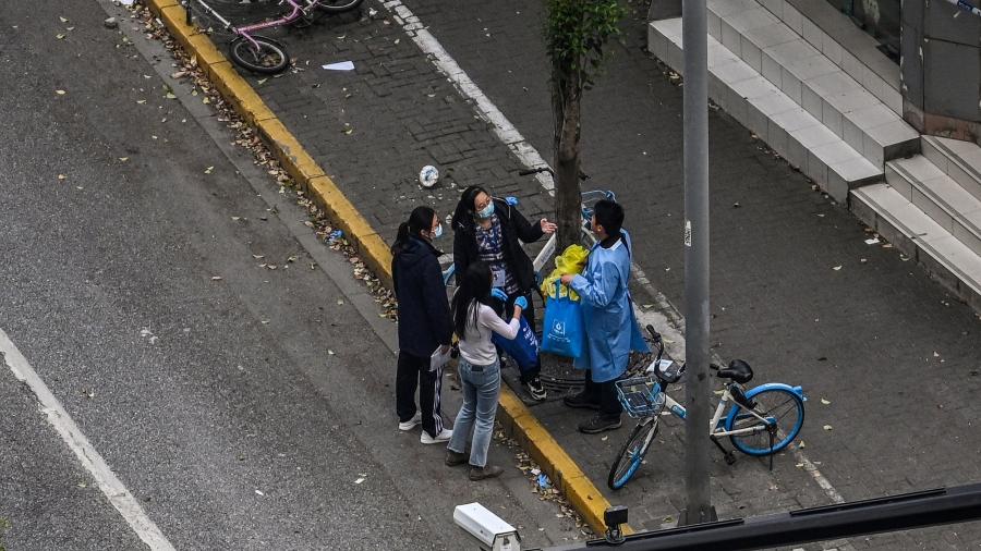 19.abr.2022 - Pessoas em uma rua durante o lockdown de covid no distrito de Jing"an, em Xangai - Hector Retamal/AFP
