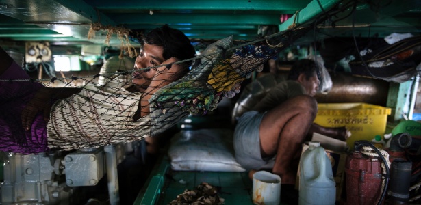 Pescadores de Mianmar descansam em um barco em Songkhla, na Tailândia - Adam Dean/The New York Times