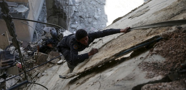 14.fev.2016 - Técnico da defesa civil trabalha sobre destroços após ataques aéreos das forças pró-sírias do governo, em Damasco - Bassam Khabieh/Reuters