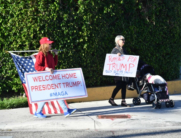10.dez.2017 - Apoiadores do presidente dos EUA, Donald Trump, dão boas-vindas a ele em Palm Beach, na Flórida - NICHOLAS KAMM/AFP