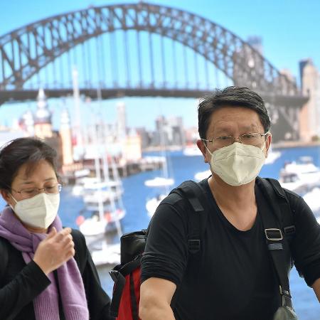 Passageiros vindos da China desembarcam no aeroporto de Sidney usando máscaras - Peter Parks/AFP