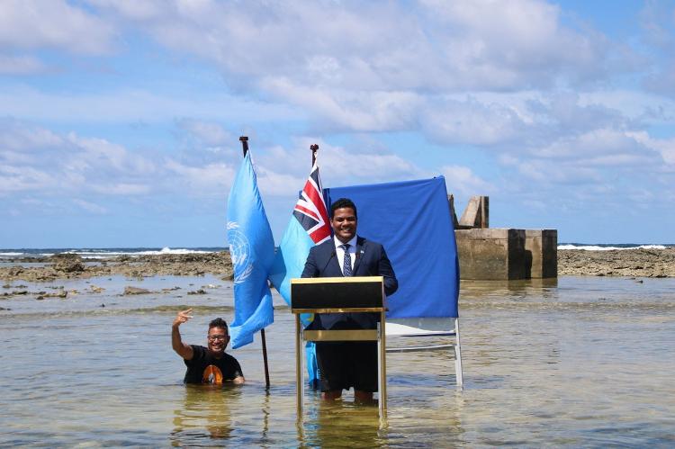 O então ministro das relações exteriores de Tuvalu, Simon Kofe, discursou na COP26, em 2021, direto de área invadida pelo oceano na capital Funafuti O então ministro das relações exteriores de Tuvalu, Simon Kofe, discursou na COP26, em 2021, direto de área invadida pelo oceano na capital Funafuti