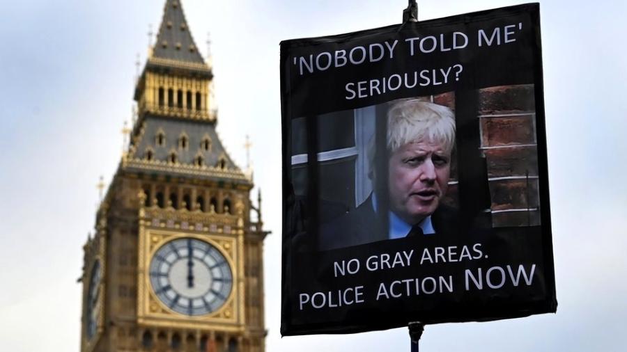 Um manifestante segura um cartaz mostrando o primeiro-ministro britânico Boris Johnson, do lado de fora do parlamento em Londres, 19 de janeiro de 2022 - Getty Images
