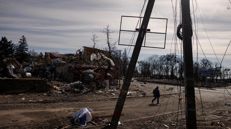 12.mar.2022 - Homem caminha entre escombros de bombardeio na vila de Byshiv, nos arredores de Kiev - REUTERS/Thomas Peter - REUTERS/Thomas Peter