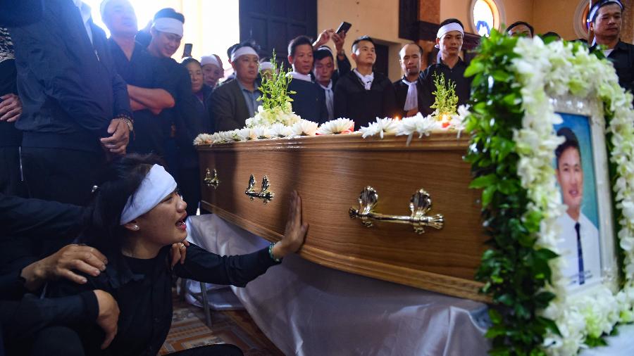 28.nov.2019 - Membro da família chora diante do caixão durante funeral de vítima de caminhão frigorífico na Inglaterra - Nhac Nguyen/AFP