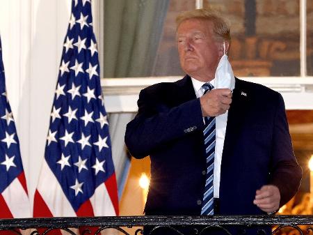 Donald Trump tira a máscara e ergue o polegar ao chegar à Casa Branca
