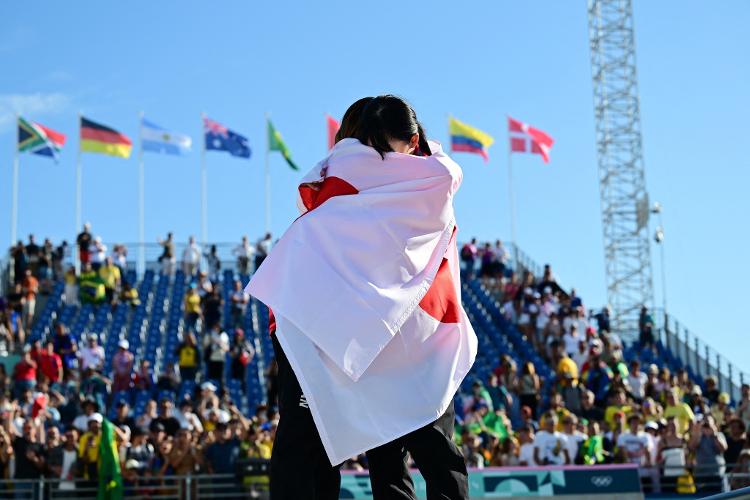 Enroladas em bandeiras do Japão, as medalhistas japonesas de ouro e prata, Coco Yoshizawa e Liz Akama, respectivamente, comemoraram a conquista abraçadas