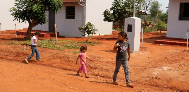 Crianças caminham pelo bairro de Santa Rosa del Aguaray, a 250 km de Assunção, uma das regiões mais pobres do país; o presidente Horacio Cortes inaugurou no local 99 casas populares