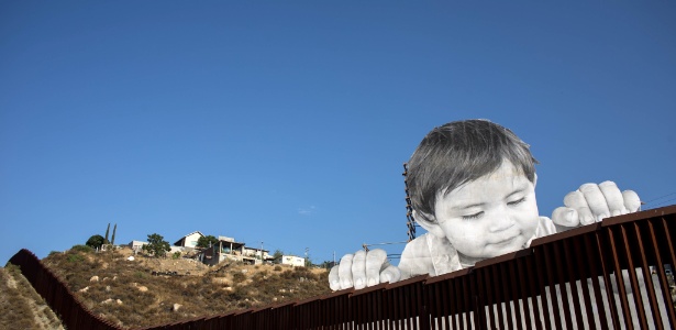 Instatalação de artista francês retrata criança sobre muro na fronteira entre México e EUA - Guillermo Arias/AFP