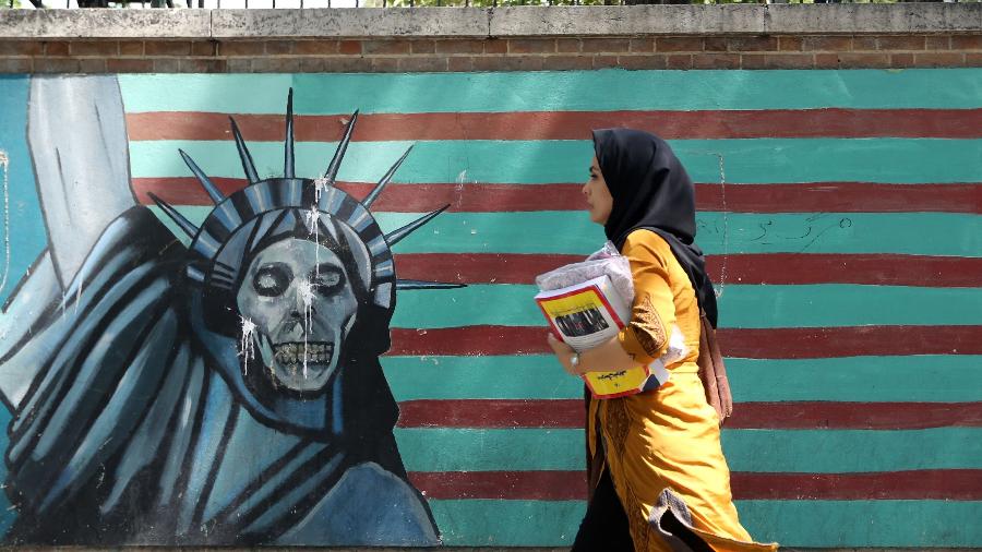 22.jun.2019 - Em Teerã, capital do Irã, mulher passa em frente a pintura no muro da antiga embaixada dos EUA. A pintura retrata a Estátua da Liberdade como uma caveira - Atta Kenare/AFP