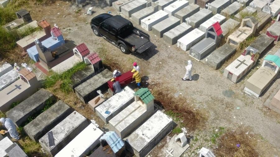 12.abr.2020 - Vista aérea de trabalhadores enterrando um caixão no cemitério Maria Canals, nos arredores de Guayaquil - Jose Sánchez/AFP