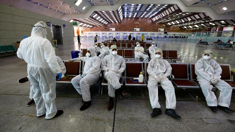 5.mar.2020 - Equipe médica iraquiana descansa após verificar a temperatura dos passageiros no aeroporto de Najaf - Alaa al-Marjani/Reuters