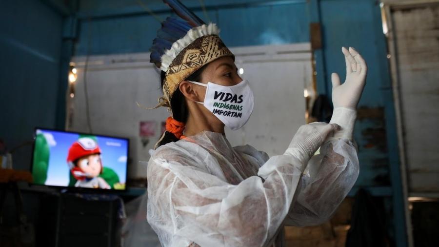 Vanda usa uma máscara com o slogan "Vidas Indígenas Importam" enquanto veste o equipamento de proteção antes de sair de casa - Bruno Kelly - 26.abr.2020/Reuters