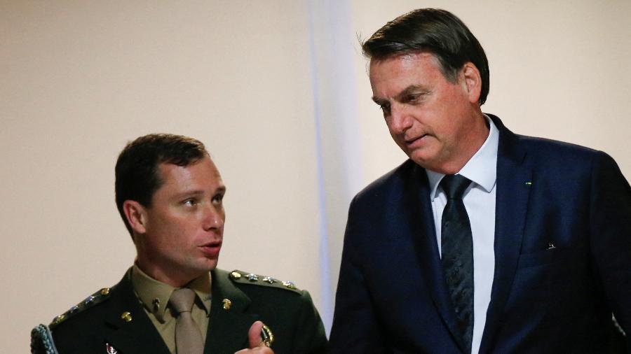 O tenente-coronel Mauro Cid, então ajudante de ordens, conversa com Bolsonaro no Palácio do Planalto - 18.jun.2019 - Adriano Machado/Reuters
