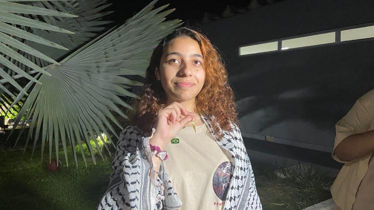 A jovem brasileira Shahed Al-Banna, mostra o colar que herdou de sua com o mapa da Palestina