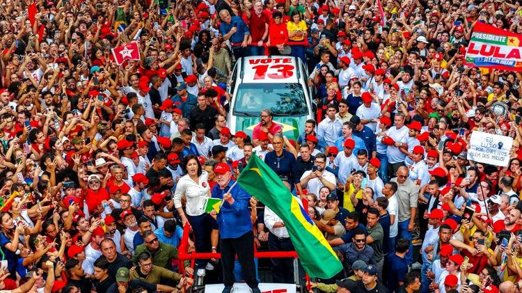 Lula segura um exemplar da Constituição e a bandeira do Brasil durante manifestação com apoiados na Paulista véspera do segundo turno