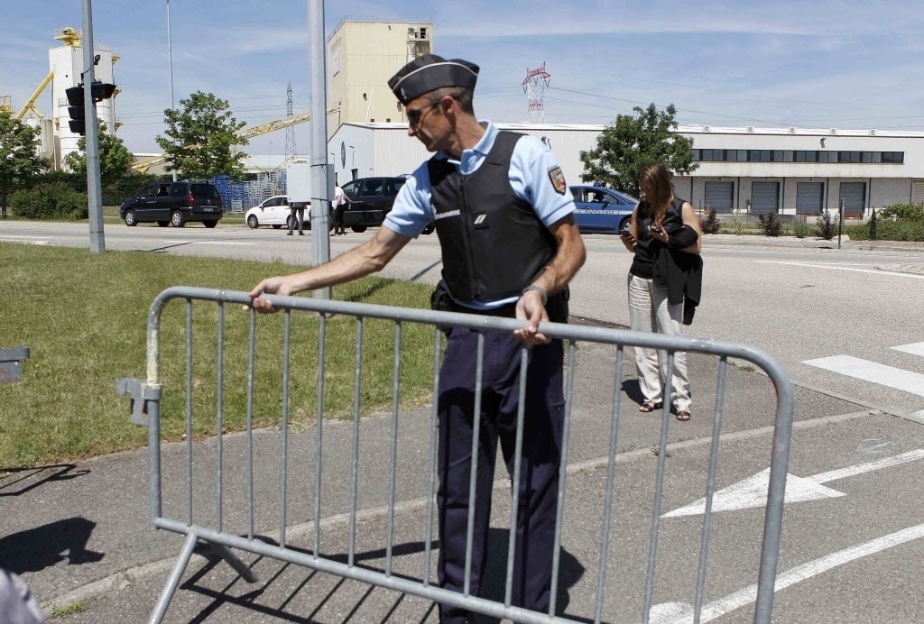 26.jun.2015 - Oficial bloqueia a estrada de acesso a usina em Saint-Quentin-Fallavier, próximo a Lyon, na França. Segundo autoridades, houve uma explosão no local após a entrada de um ou mais indivíduos. Foram encontrados uma bandeira com inscrições em árabe e um corpo decapitado - Emmanuel Foudrot/Reuters