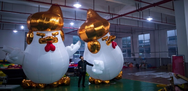 Funcionário observa frango gigante que lembra Donald Trump em fábrica em Jiaxing, China - Johannes Eisele/ AFP