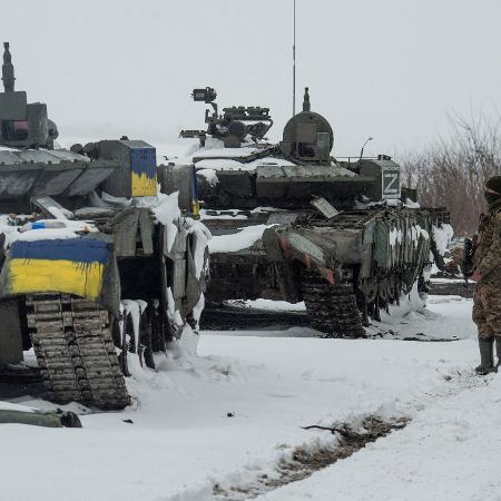 Soldados ucraniano ao lado de tanques russos capturados no norte da região de Kharkiv, na Ucrânia - REUTERS