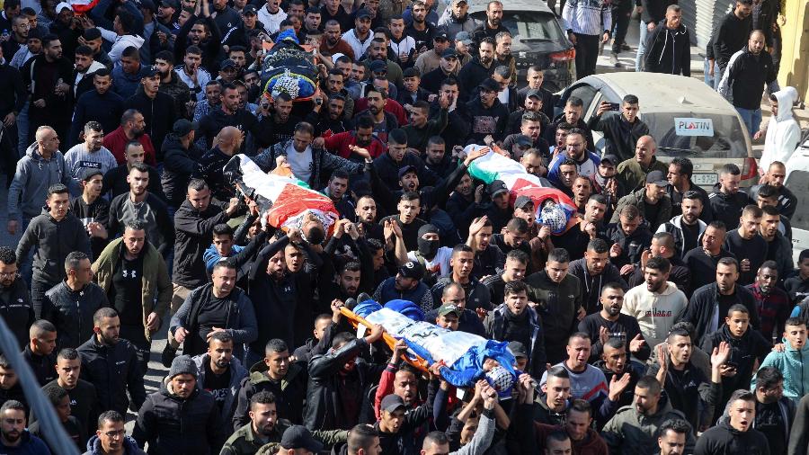 26.jan.2023 - Palestinos carregam os corpos de quatro das nove vítimas relatadas mortas durante um ataque israelense ao campo de refugiados de Jenin, na Cisjordânia - Jaafar Ashtiyeh/AFP