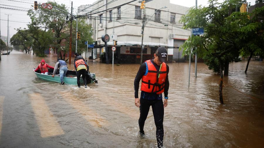 Rmador pré-olímpico brasileiro Piedro Tuchtenhagen caminha após carregar um barco usado para resgatar vítimas de enchentes em Porto Alegre em 10 de maio de 2024