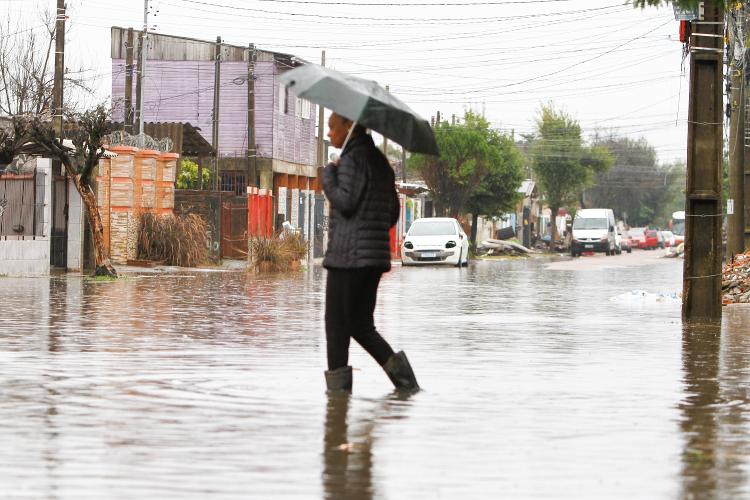 Homem usa galocha para atravessar enchente no bairro Mathias Velho, em Canoas, região metropolitana de Porto Alegre Homem usa galocha para atravessar enchente no bairro Mathias Velho, em Canoas, região metropolitana de Porto Alegre