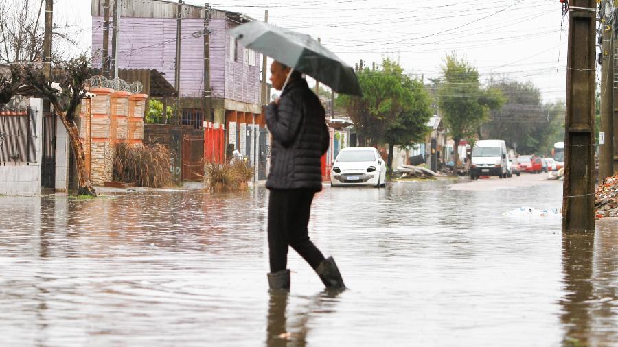 Homem usa galocha para atravessar enchente no bairro Mathias Velho, em Canoas, na região metropolitana de Porto Alegre, no Rio Grande do Sul Homem usa galocha para atravessar enchente no bairro Mathias Velho, em Canoas, na região metropolitana de Porto Alegre, no Rio Grande do Sul