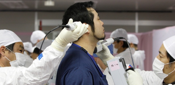 Empregado passa sob controle em Fukushima, em fevereiro de 2012, quase um ano após a tragédia. - Issei Kato/AFP