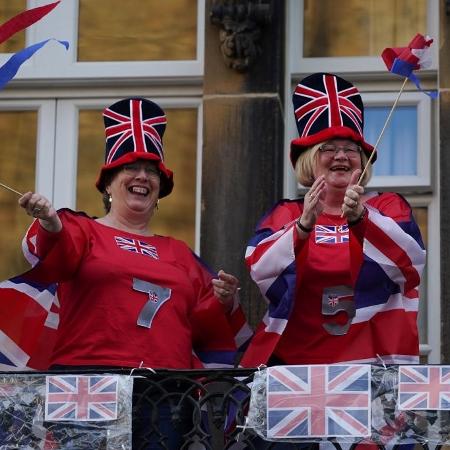 7.mai.2020 - Vestidas com bandeiras do Reino Unido, mulheres homenageiam profissionais do NHS, sistema público de saúde do país - Ian Forsyth/Getty Images