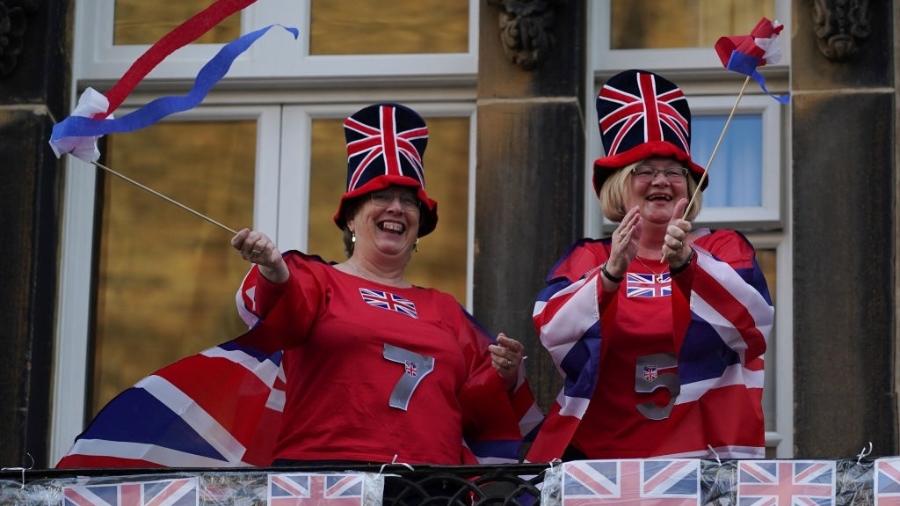 7.mai.2020 - Vestidas com bandeiras do Reino Unido, mulheres homenageiam o NHS, sistema público de saúde do país - Ian Forsyth/Getty Images
