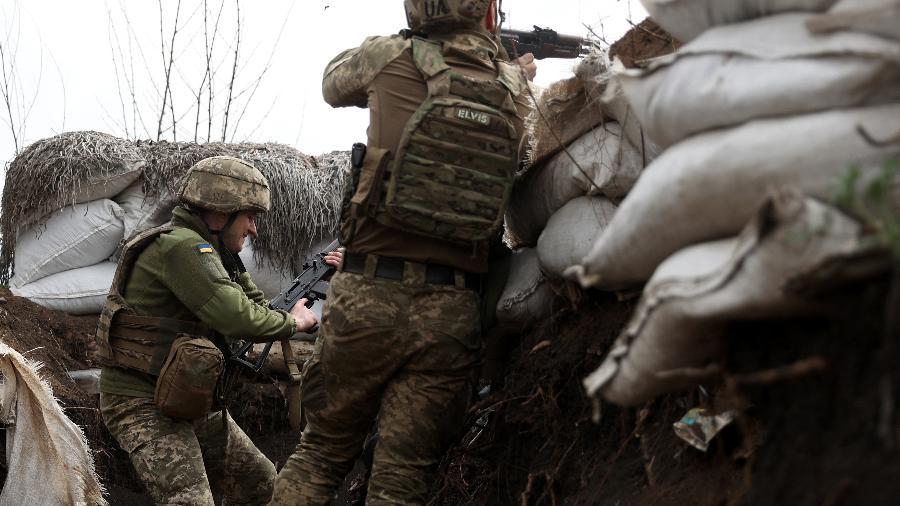11.abr.2022 - Soldados ucranianos atiram com rifles de assalto em uma trincheira na linha de frente com tropas russas na região de Lugansk