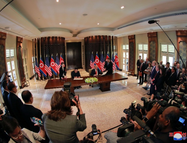12.jun.2018 - Donald Trump e Kim Jong-un assinam documento durante a cúpula entre os líderes dos Estados Unidos e Coreia do Norte em Singapura - KCNA via REUTERS 