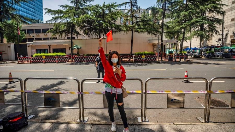 26.jul.2020 - Mulher posa para foto em frente ao consulado dos Estados Unidos em Chengdu, na China, que foi fechado após tensão entre os países  - EFE/EPA/Alex Plavevski