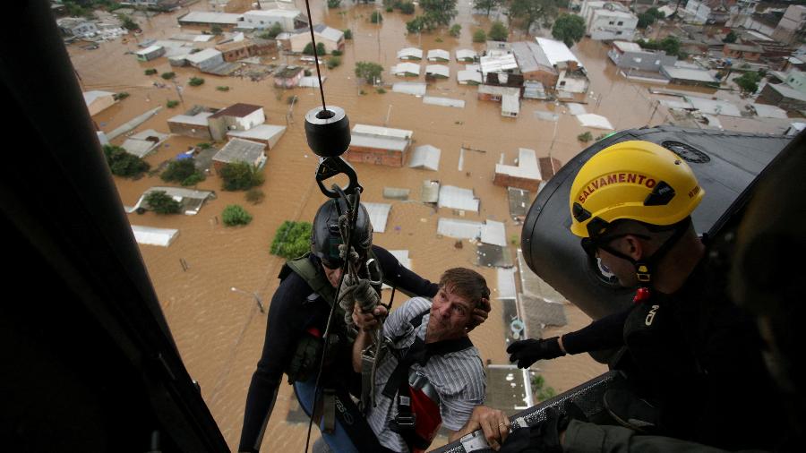 Homem é resgatado por bombeiros militares após enchentes em Canoas (RS) - Renan Mattos - 4.mai.24/Reuters