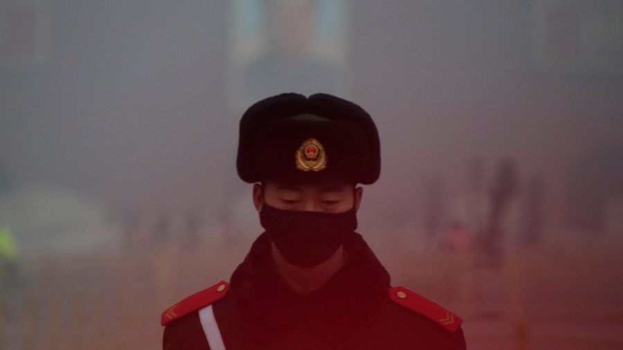 20.dez.2016 - Policial militar de guarda na Praça Tiananmen, usa máscara na frente de um retrato do falecido presidente Mao Zedong durante dia de alerta vermelho de poluição atmosférica em Pequim, na China - Jason Lee/Reuters